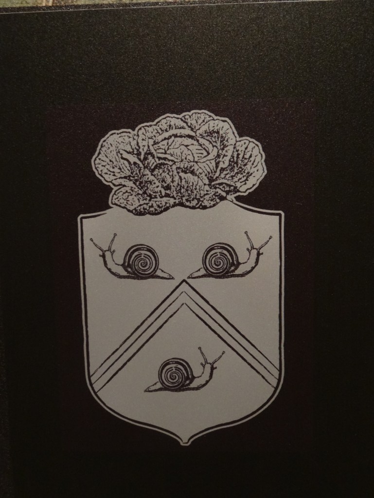 Le Notre's coat of arms, complete with cabbage and slugs.